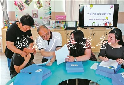 无锡市广新小学校长过秦勇(右三)、副校长朱甄珍(右一)与梁溪区特教指导中心资源教师陈向华(右二),和学生小芮及家长一起商量个别化教育方案。